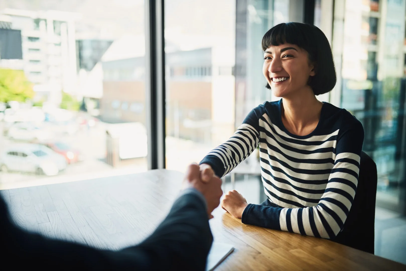 Two businessmen shaking hands to finalize a salary negotiation deal in a corporate office