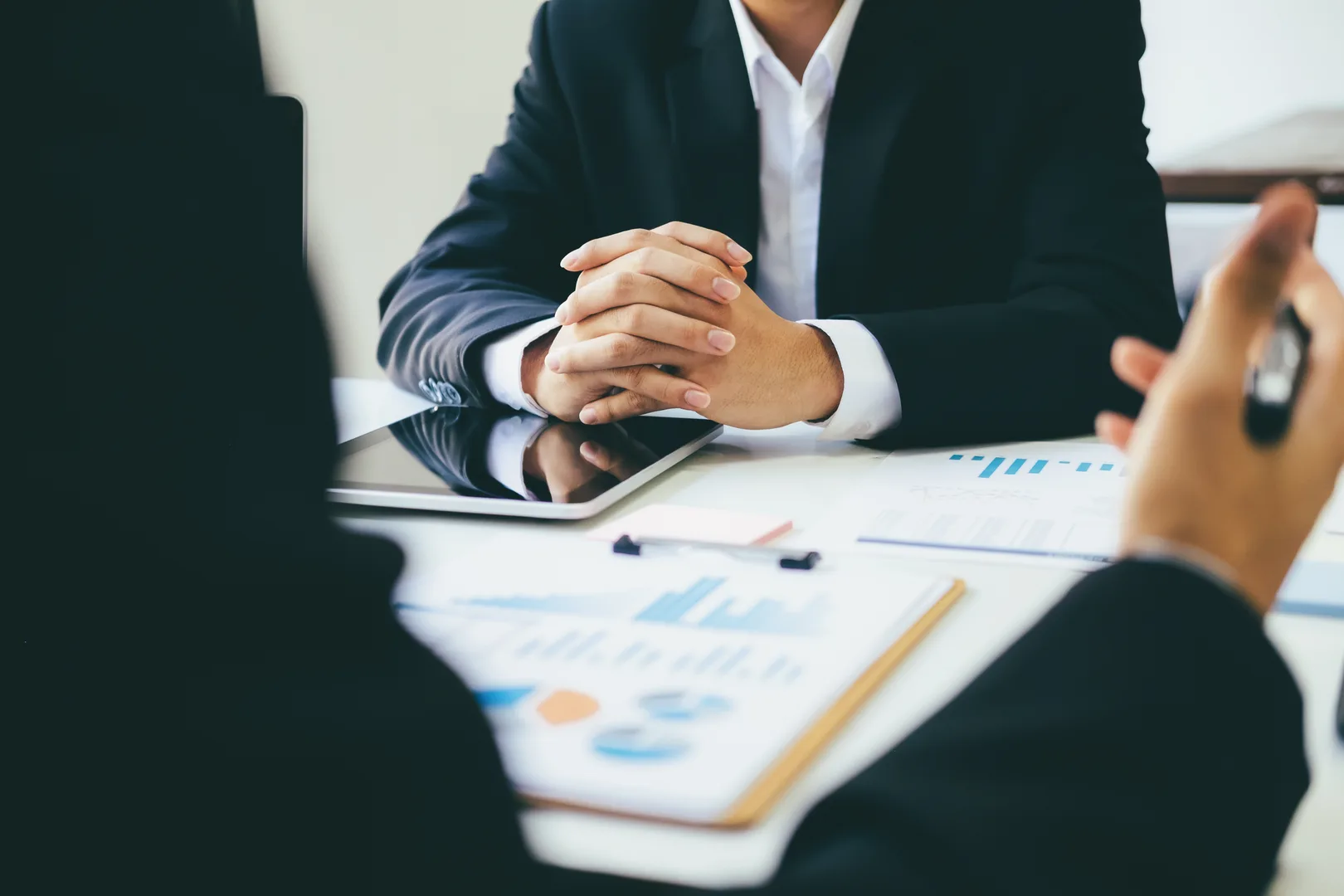 Business professionals discussing salary data and financial charts in a meeting