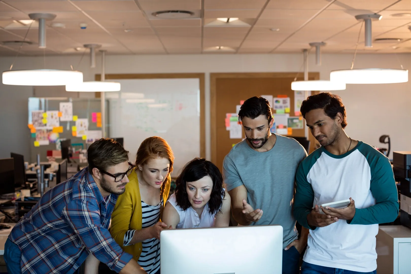 Creative team discussing AI strategy and future of work around a modern office table