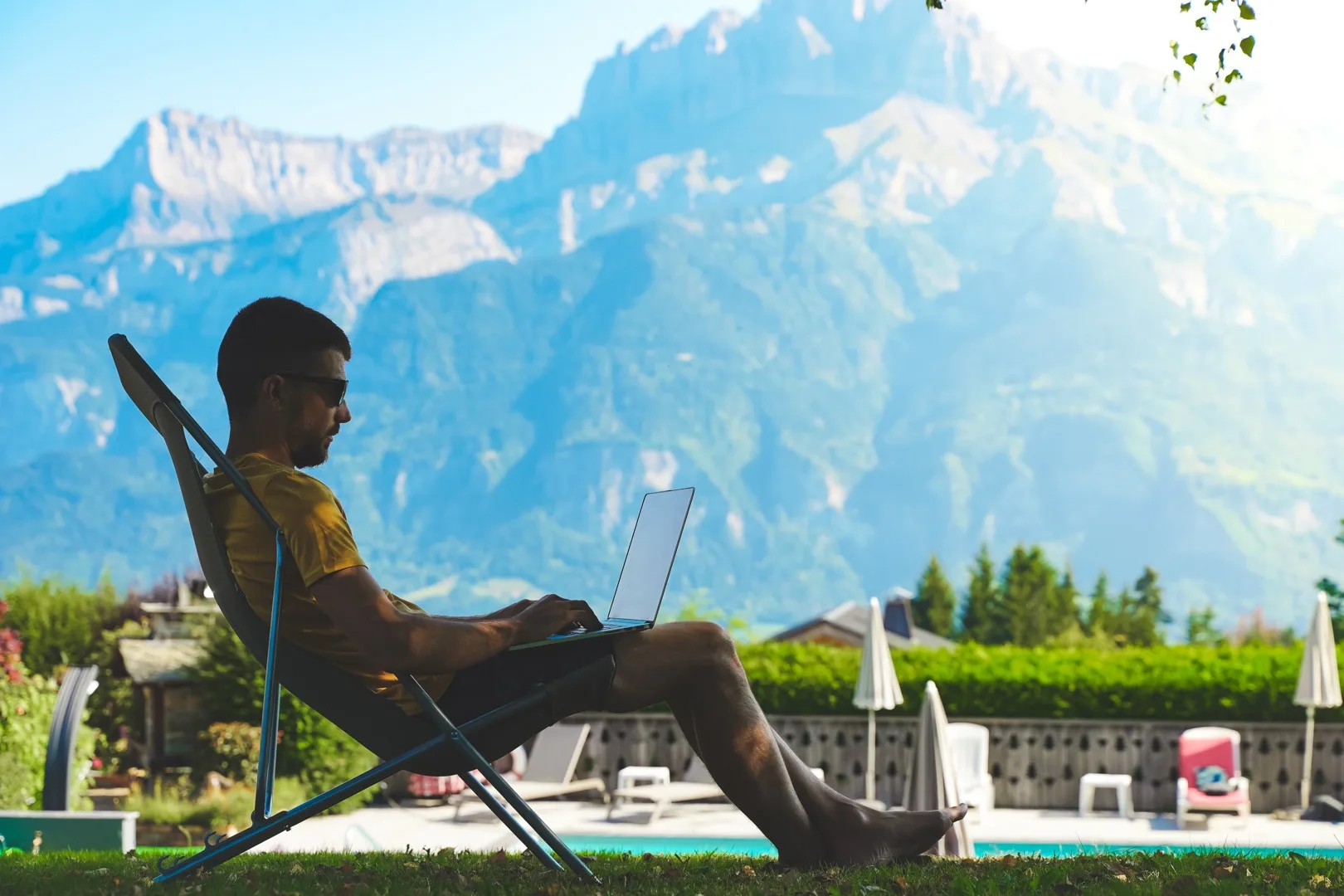 Digital nomad working remotely from a scenic location with laptop and mountain view