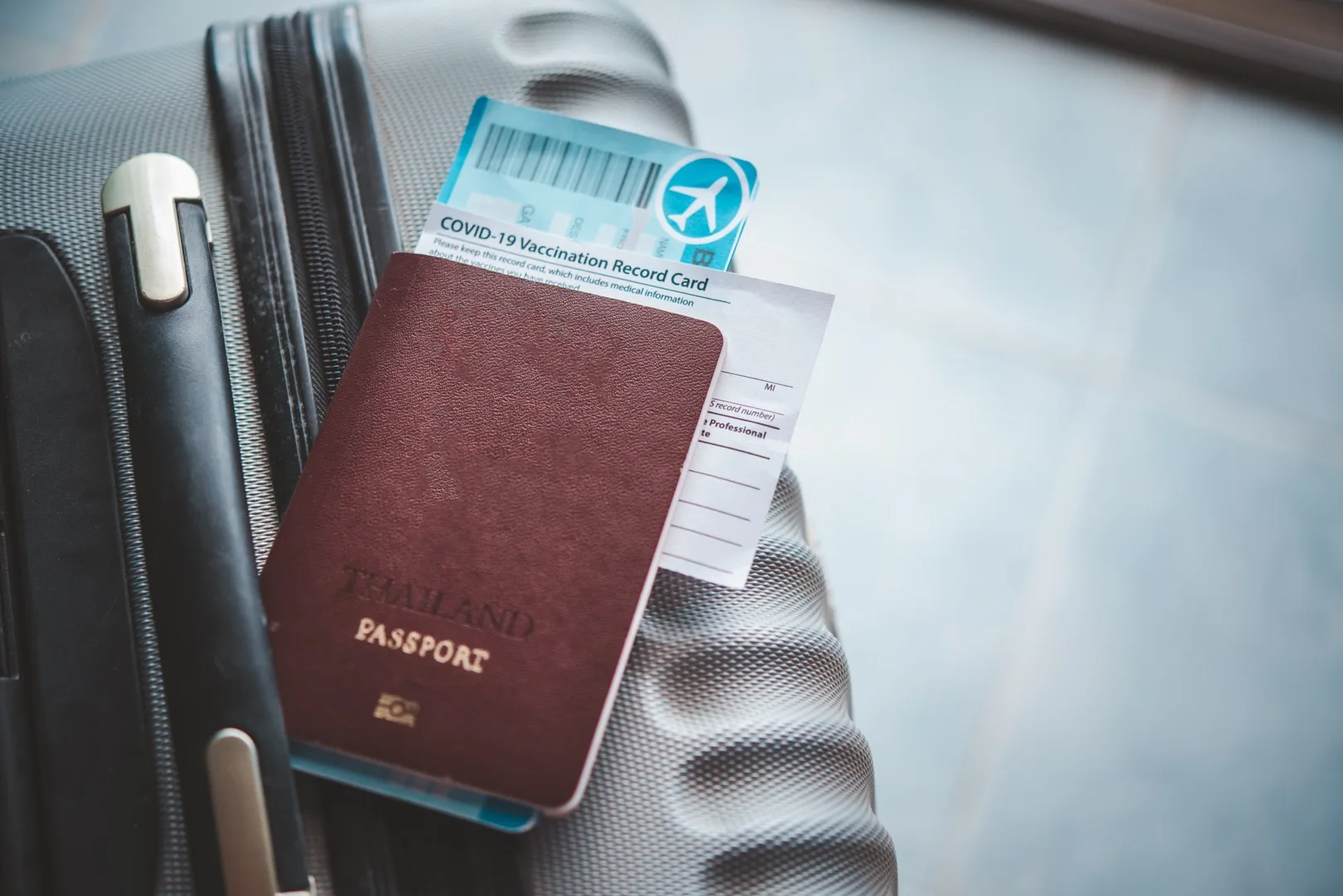 Passport and boarding pass resting on a packed suitcase ready for international relocation