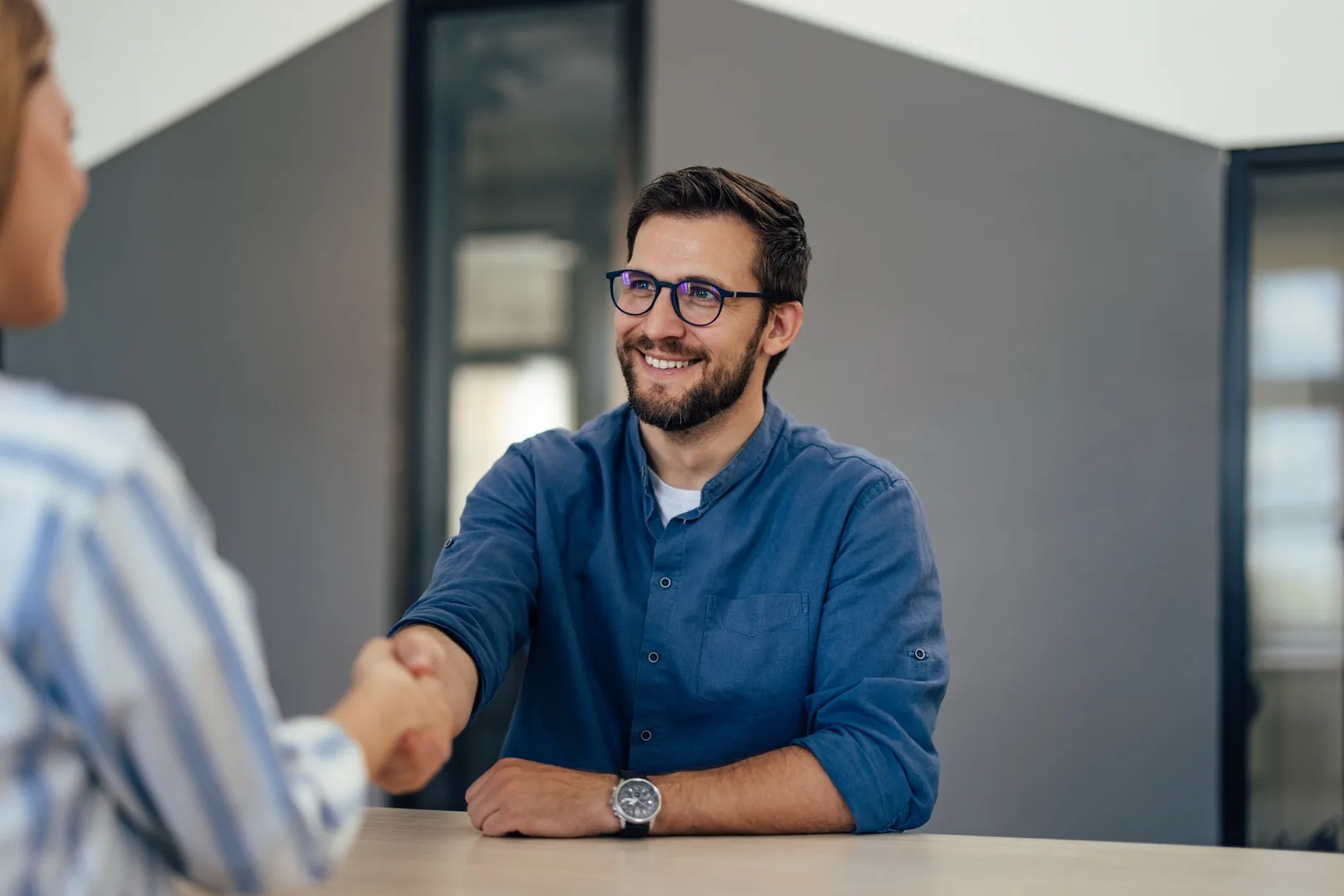 Two professionals shaking hands after a successful salary negotiation