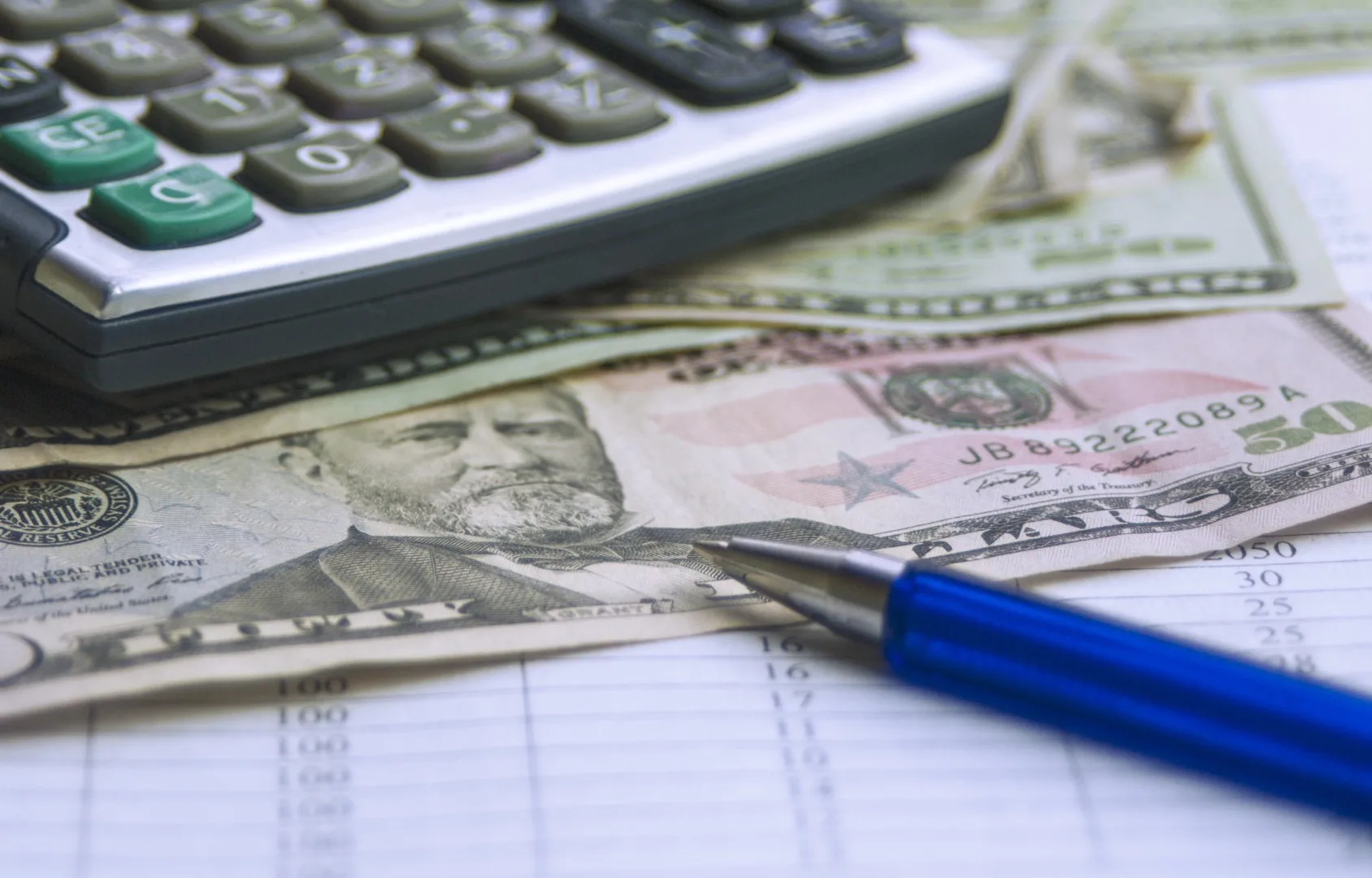 Salary calculation setup with calculator, pay stubs, and pen for tax rate analysis