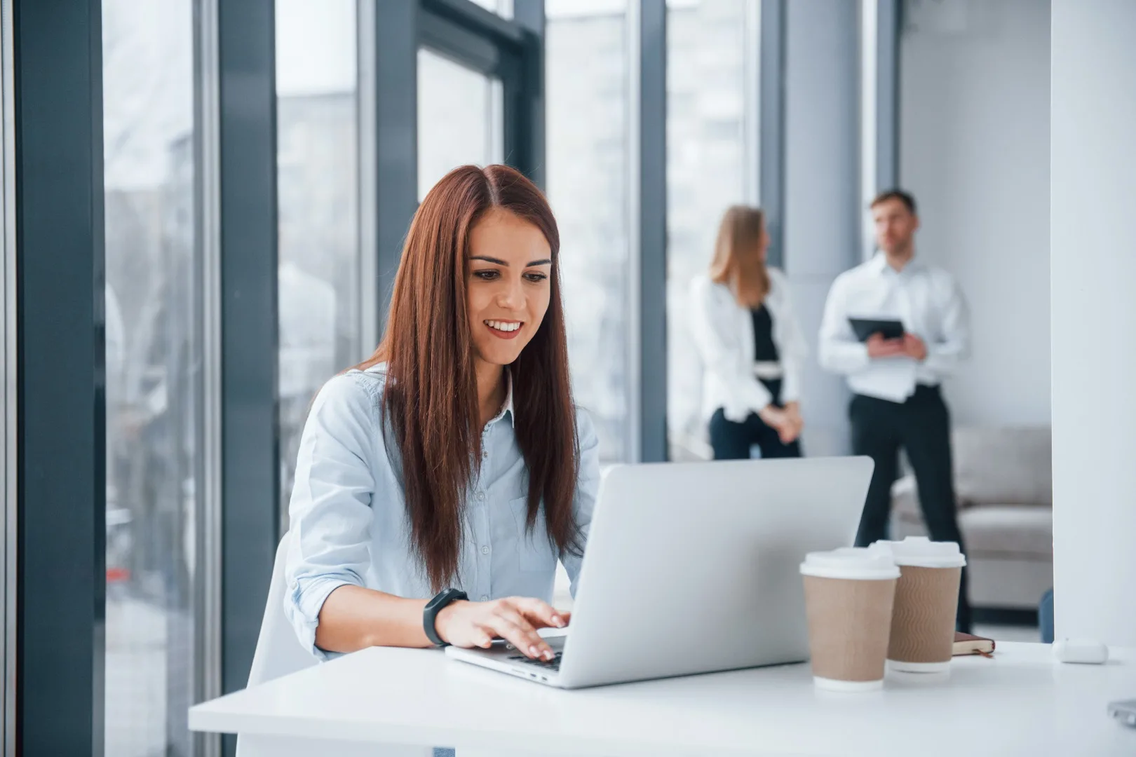Professional woman presenting to a group in a modern office setting